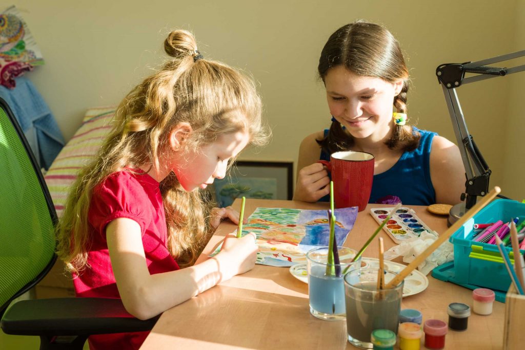 girls sisters at home at the table paint with wate 2026 01 07 06 02 13 utc